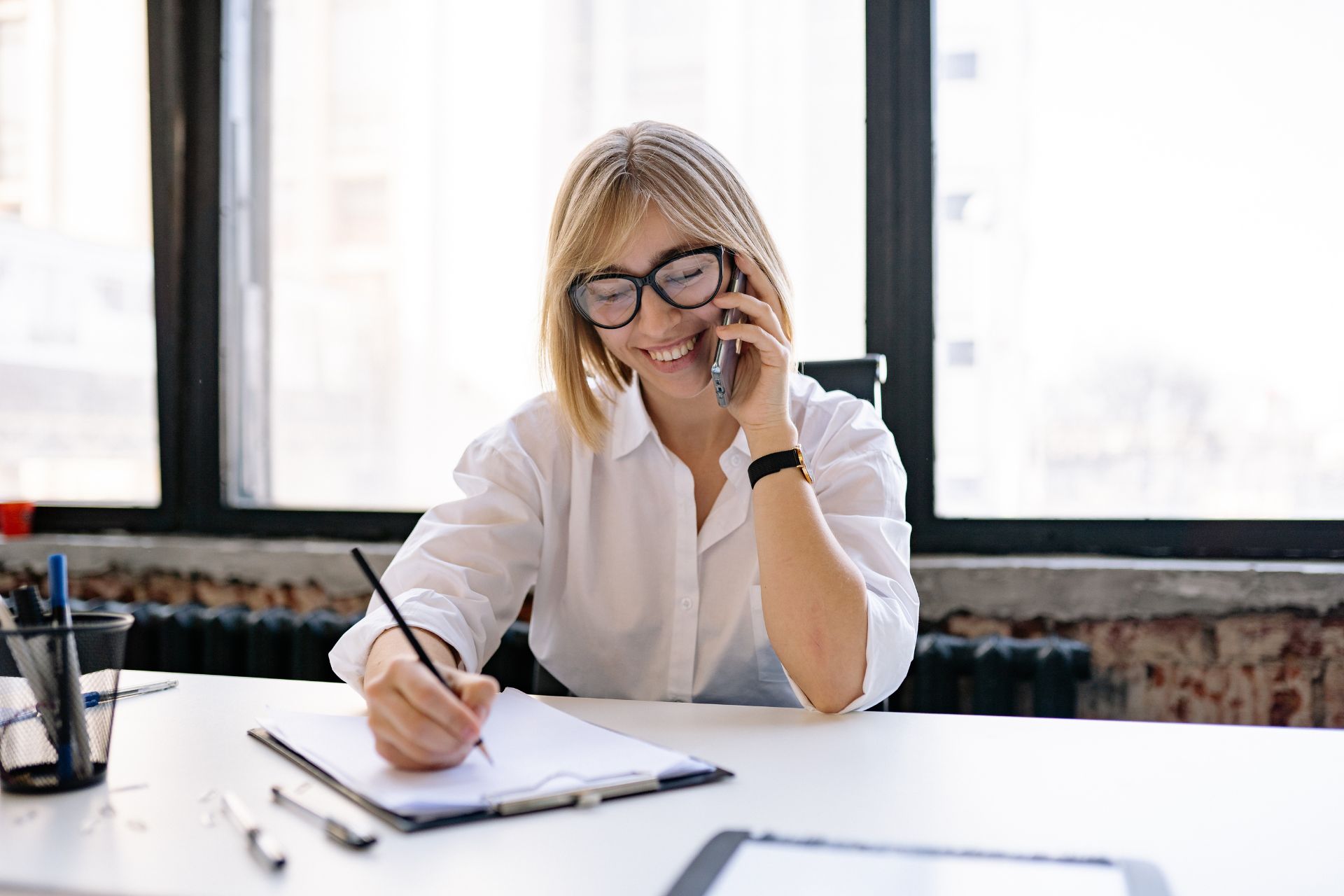 Woman on Phone Taking Notes